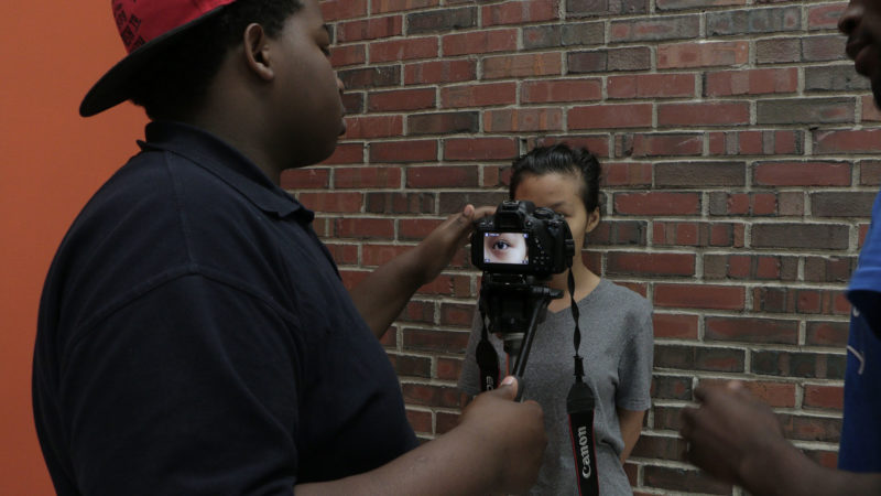 A student holding a camera to a student