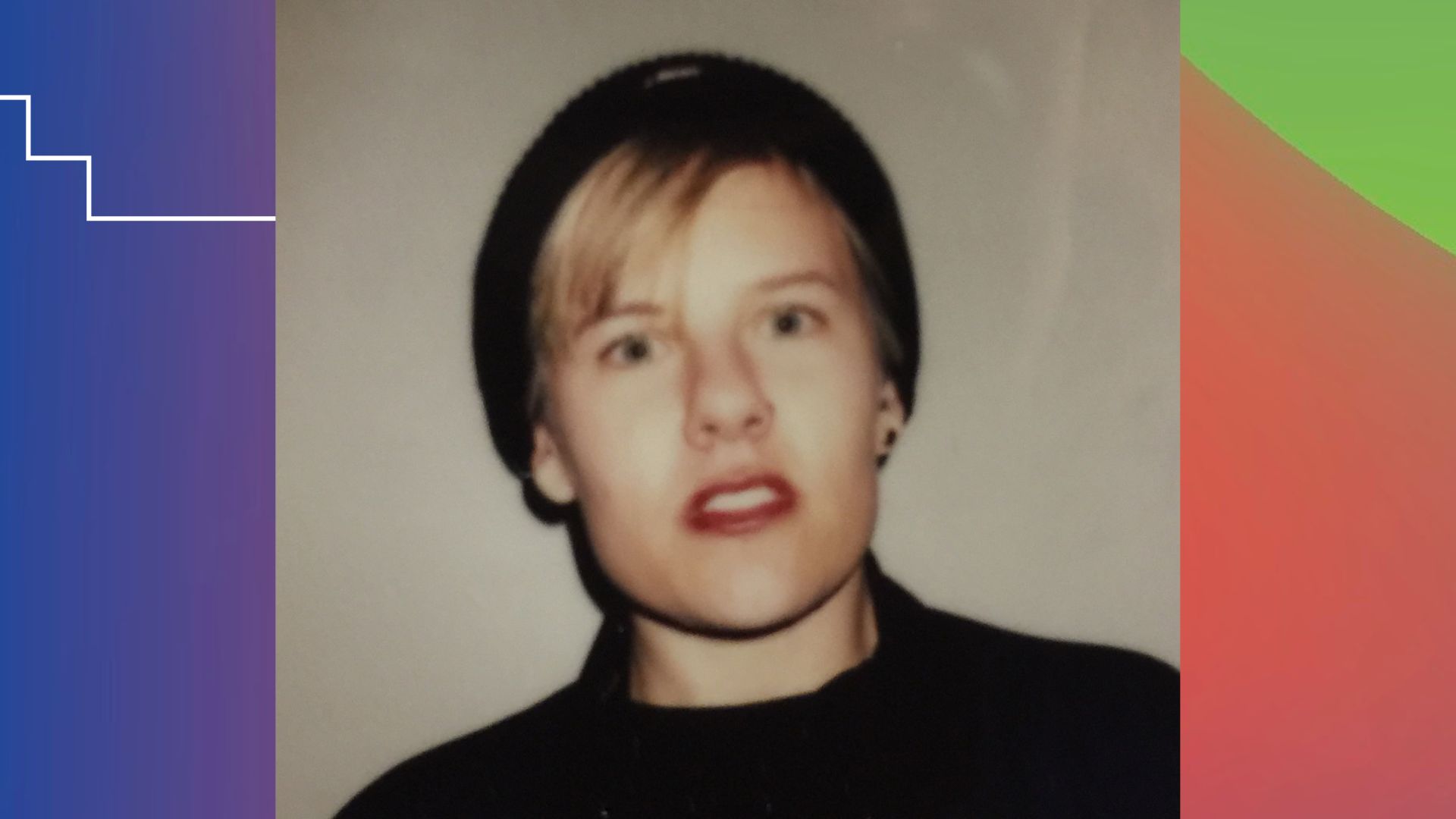 Maggie Hazen, a white queer person from Southern California. She has blonde hair and is wearing a black beanie hat and a black sweater. She is candidly looking into the camera with a curious gaze.