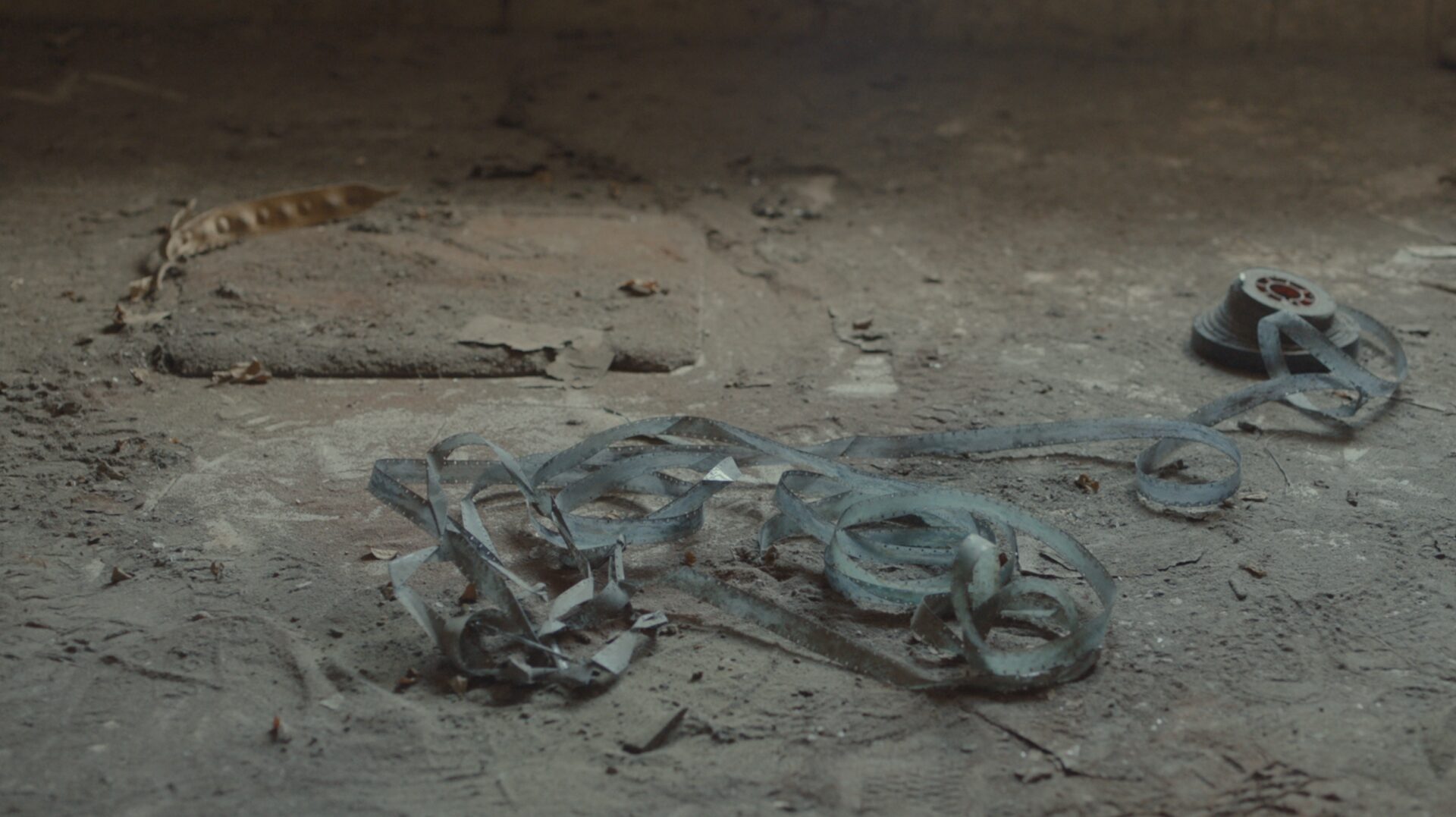 A still from Onyeka Igwe's No Archive Can Restore You. A blue bunch of 16mm film on a dusty floor.