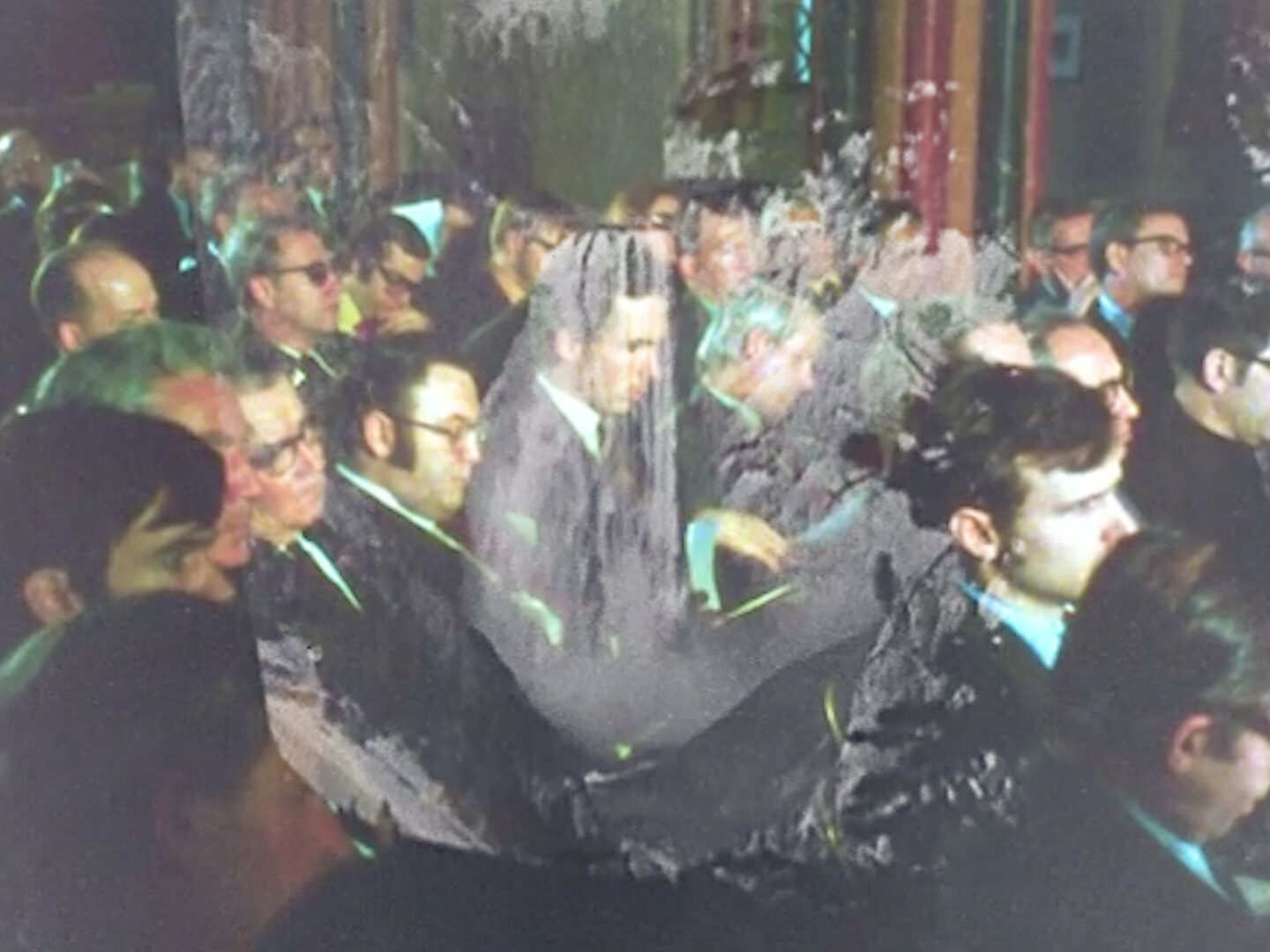 Audience of seated men attending a petroleum conference in the 1950s overlaid with a waterfall in a National Park.