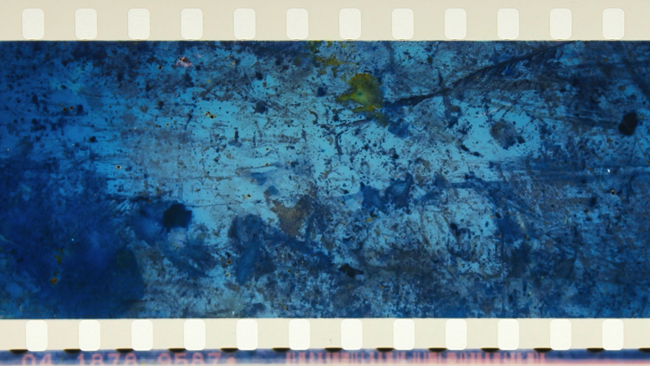 A blue speckled film strip by Tomonari Nishikawa that was buried for a period near the Fukushima Nuclear Reactor after its disaster.