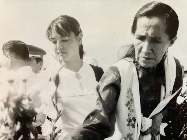 Three people in line to leave flowers.