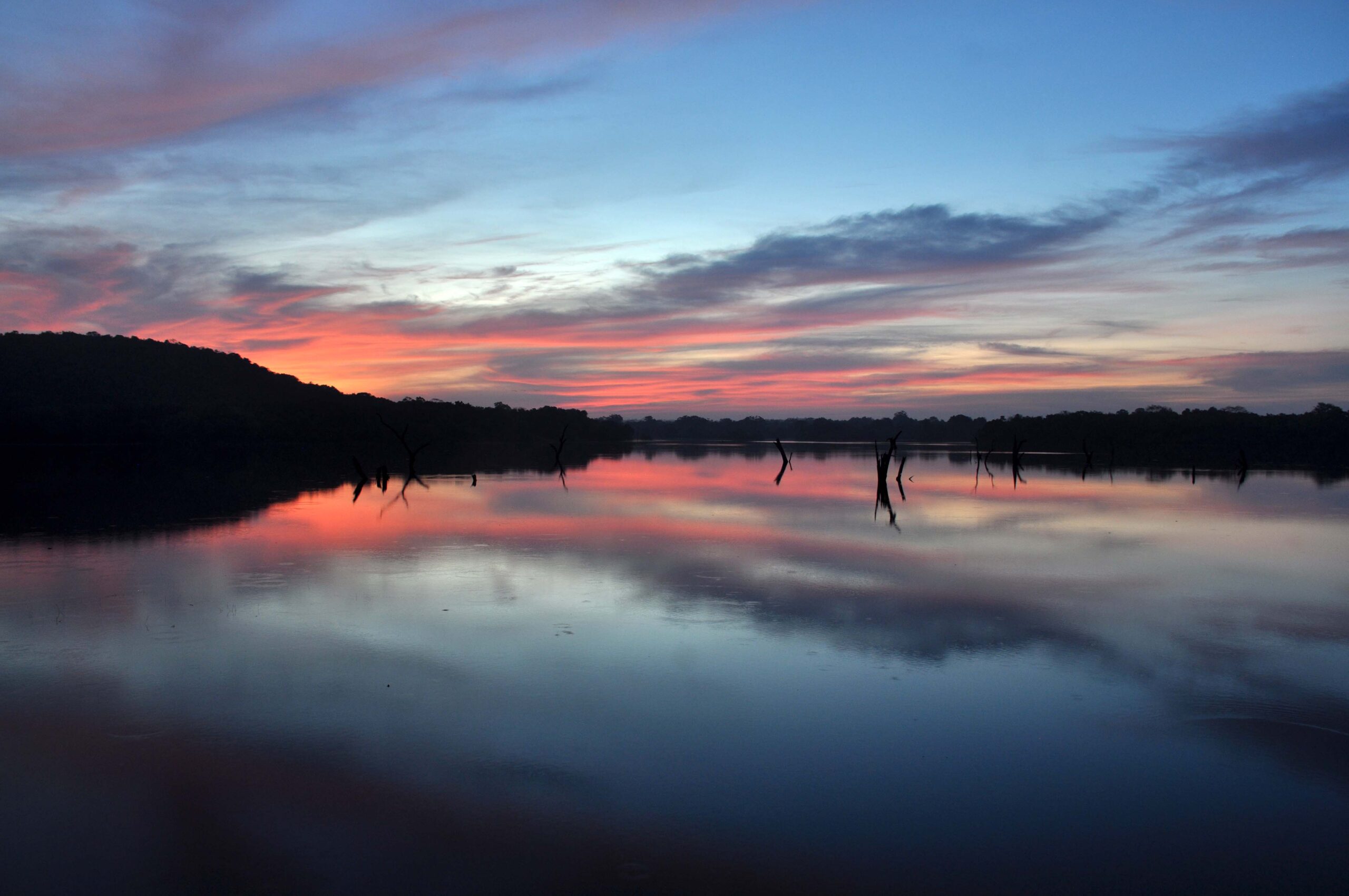 A blue and orange sunset of water and sky, with hills in shadows in the Dutuwewa region of Sri Lanka.
